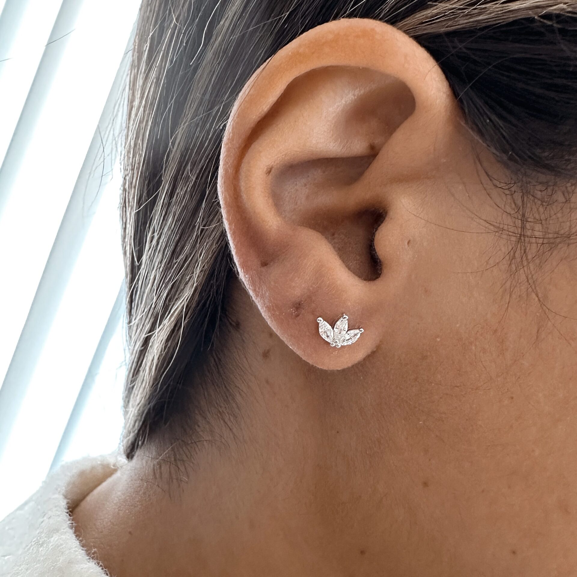 עגיל פרח הלוטוס כסף אמיתי 925 משובץ זרקונים על אוזן של דוגמנית