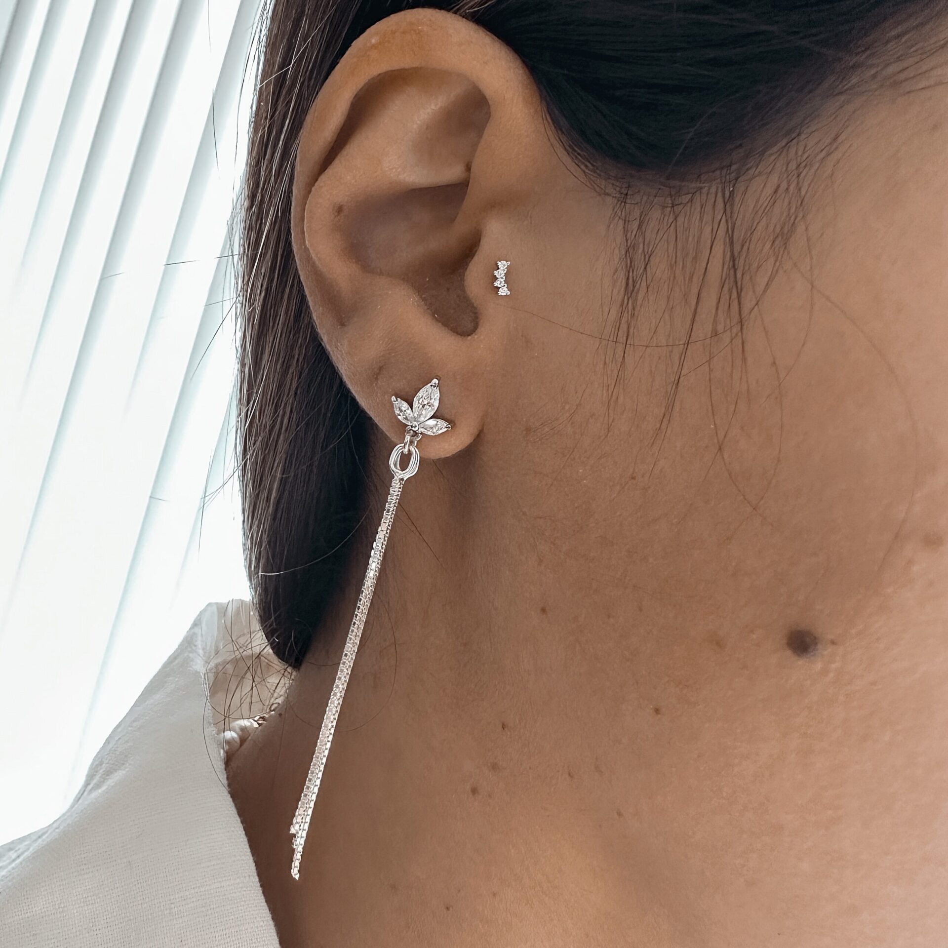 עגילי מונסון כסף 925 בעיצוב עלה משובץ זירקונים עם תליון שרשרת ארוכה על אוזן אישה