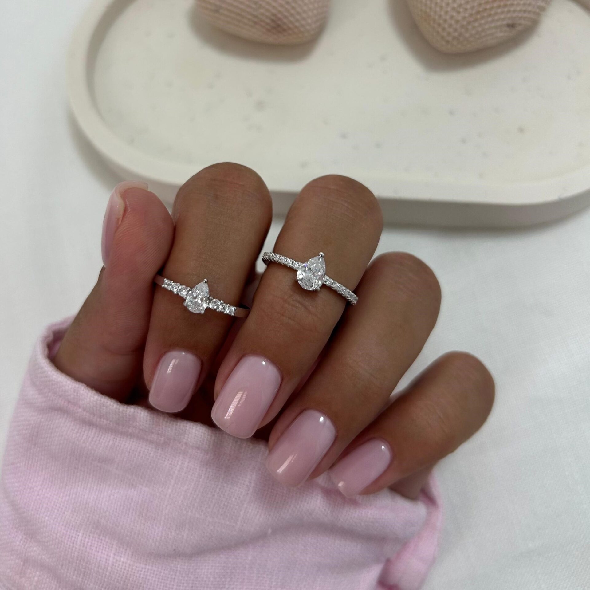 טבעת טיפה סאן טבעת כסף אמיתי 925 משובצת זירקוניה בצורת לב עם שיבוץ צדדים, על אצבע של יד מטופחת עם לק ורוד