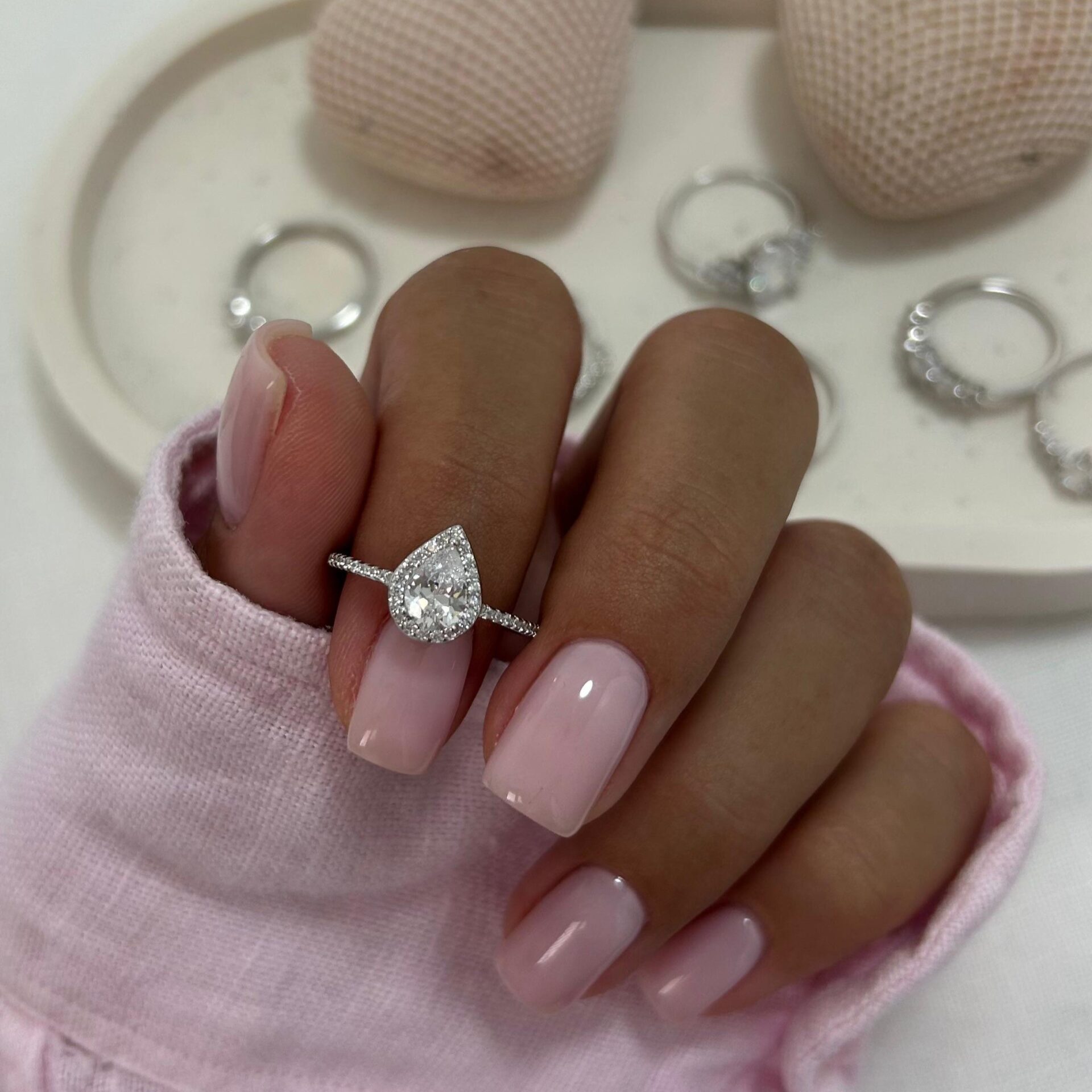 טבעת טיפה כסף אמיתי 925 משובצת זרקונים נוצצים על אצבע עם לק ורוד עדין, תכשיט יוקרתי ומרשים