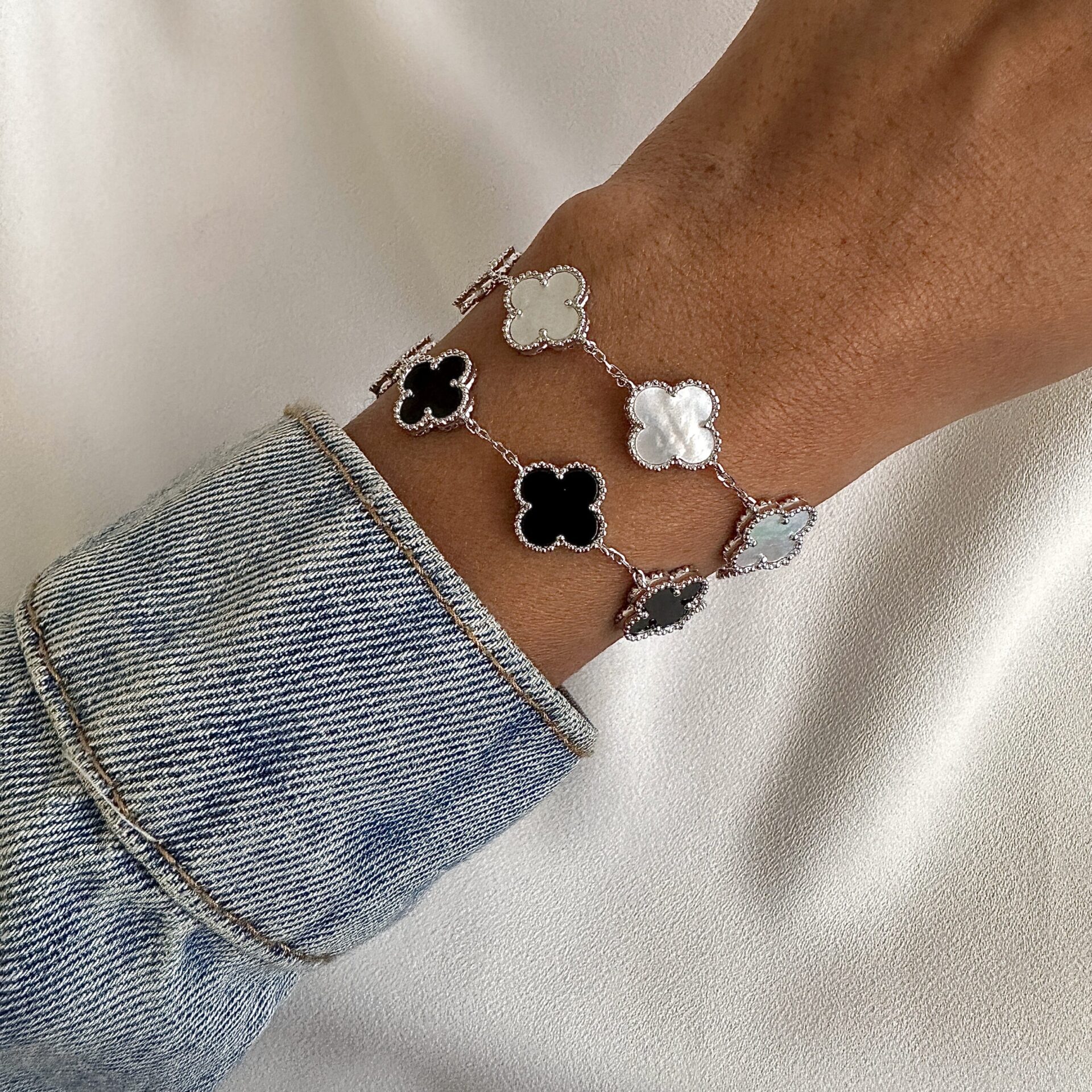 צמיד כסף 925 בסגנון וואן קליף עם תליון תלתן שחור ולבן על פרק יד אישה